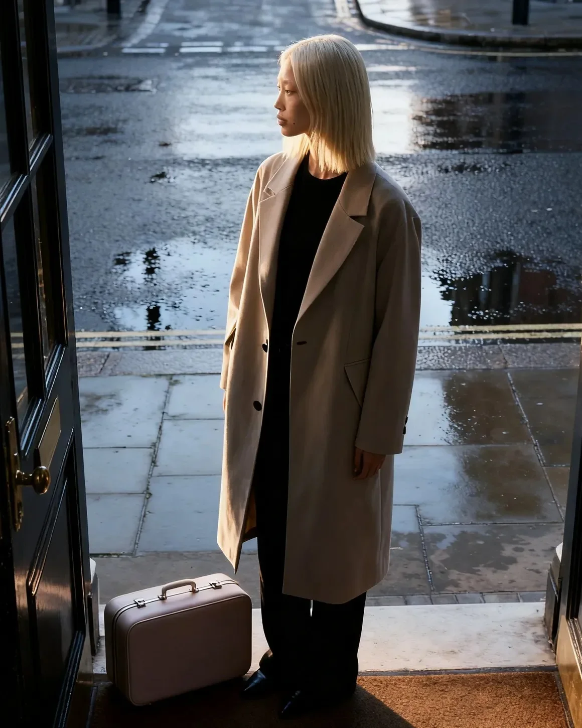 Editorial portrait of synthetic talent Aiko Velora in contemporary minimalist tailoring against neutral interior light